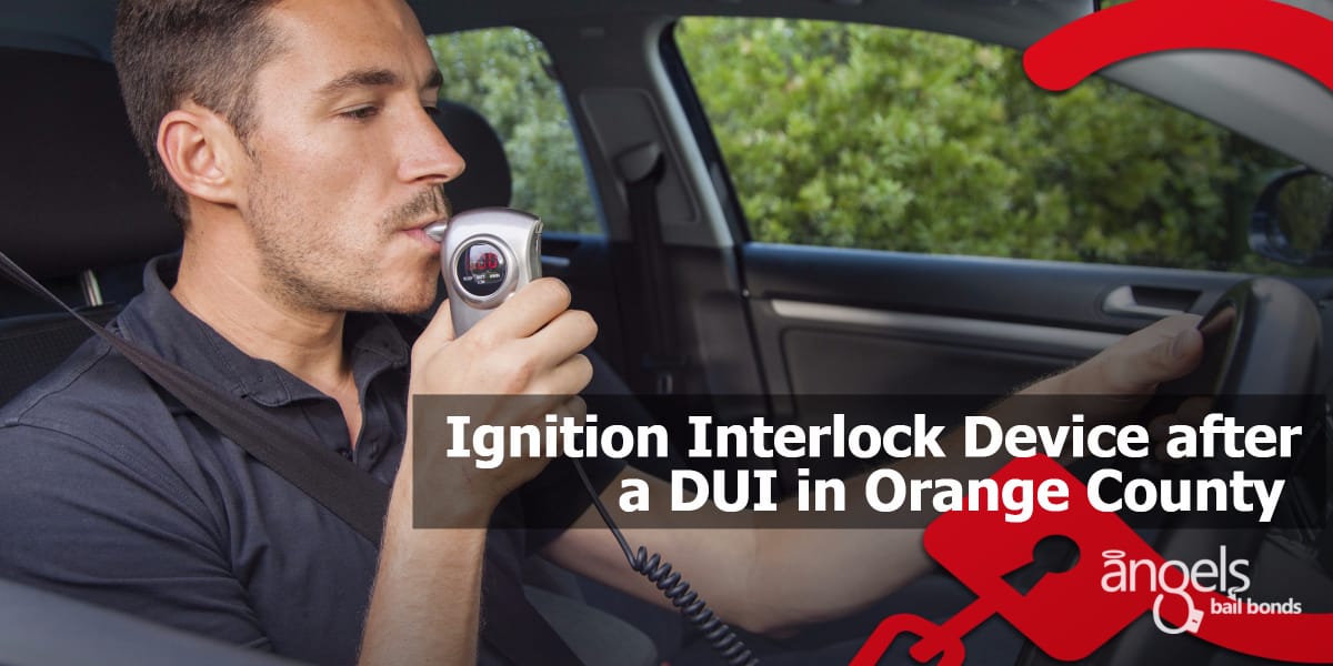 a man blowing into an ignition interlock breathalyzer in his car